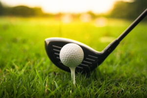 Golf club and ball in green grass