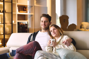 Couple sitting together on couch at home