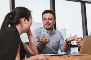 Man speaking at business meeting to colleague