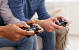 Male hands holding video game controllers