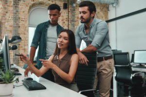 Woman showing male colleagues something on her computer