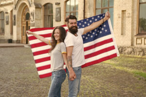 Man and woman holding opposite ends of American flag