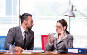 Woman and man having serious discussion at desk