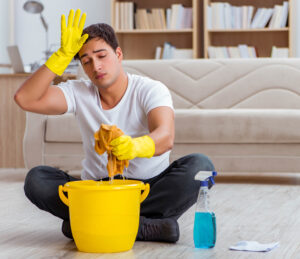 Stressed man cleaning the house