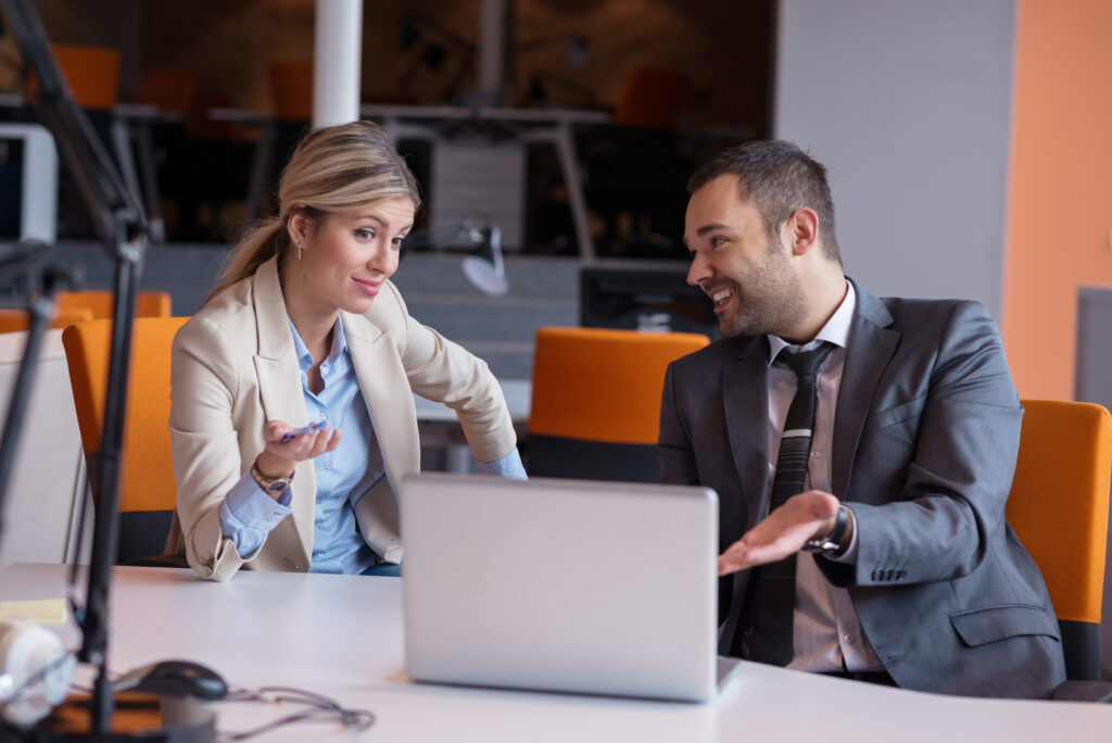 man and women talking about something on computer at work