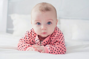 Cute baby girl on the white bed