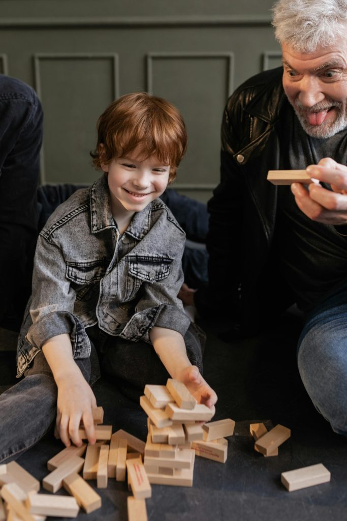 Baby Boomer Playing Game of Jenga with Grandchildren