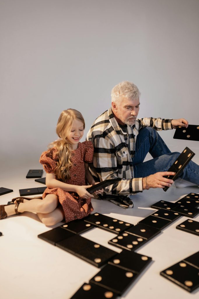 Baby Boomer Playing Game of Dominoes with Grandchildren